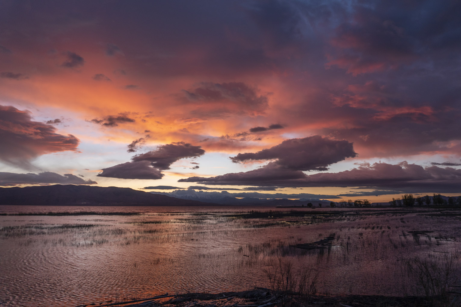 Brilliant orange, red, and purple sunset over the orange-red lake